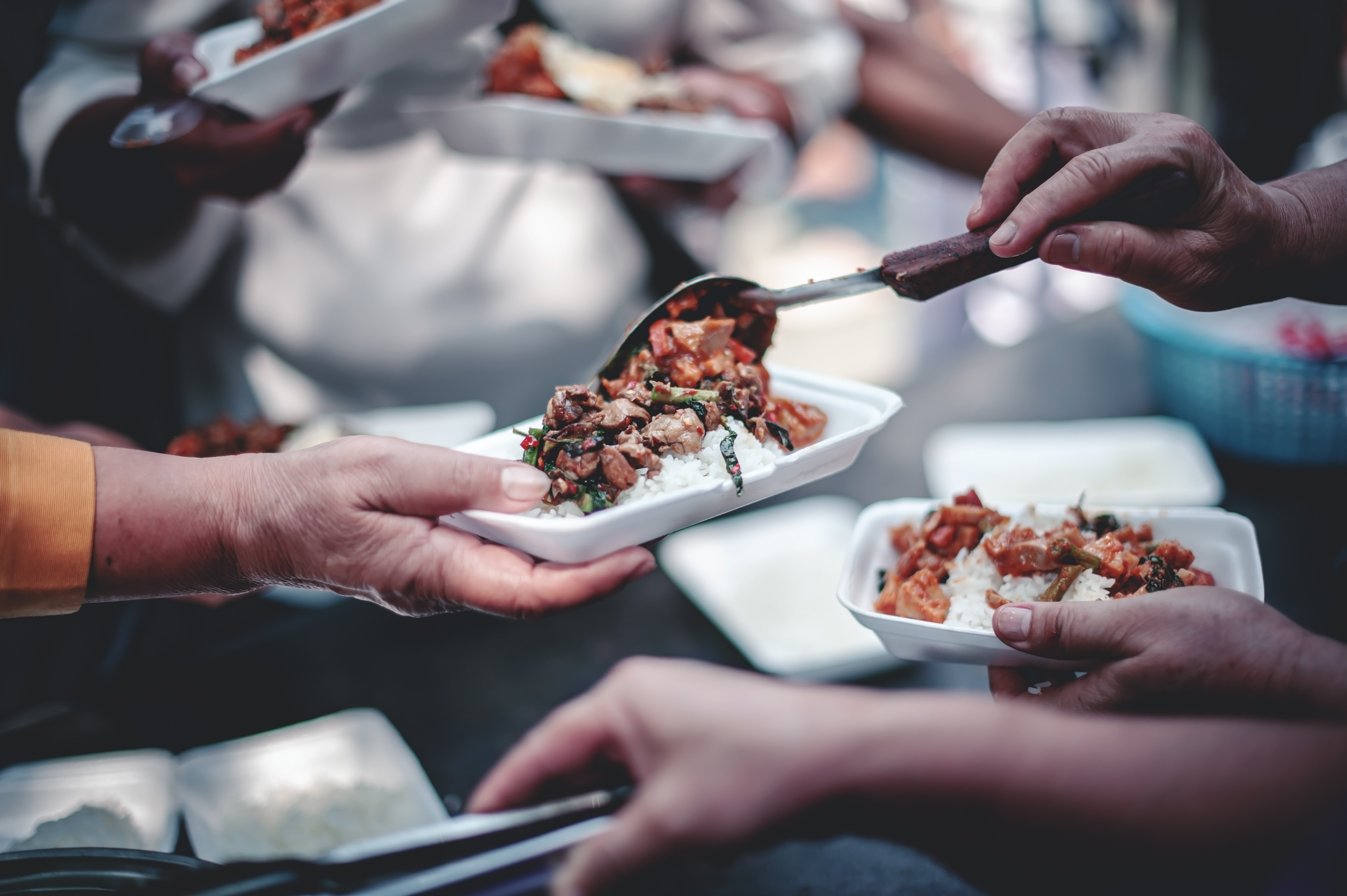 Volunteers are helping to give free food to the hungry homeless : food service and food donation concept